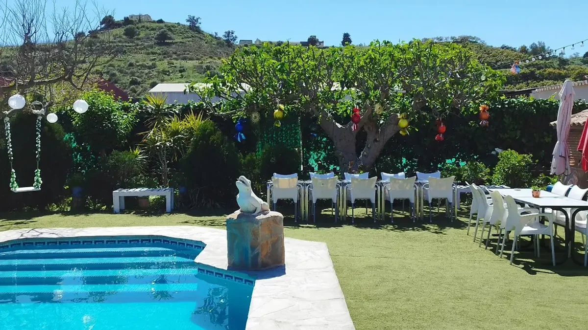 Piscina y jardín de Villa Meli, en Las Lagunas de Mijas, con un columpio y el campo al fondo