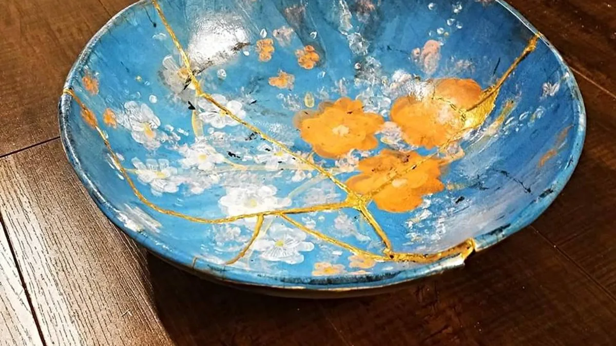 Cuenco de cerámica roto y reparado con kintsugi, con las grietas selladas en oro